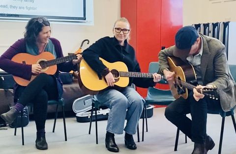 CUSP facilitators making music together — guitar, accordion and harmonica