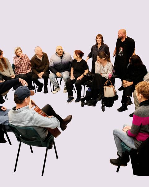 A CUSP group session in a circle — singing, hands raised, full of energy